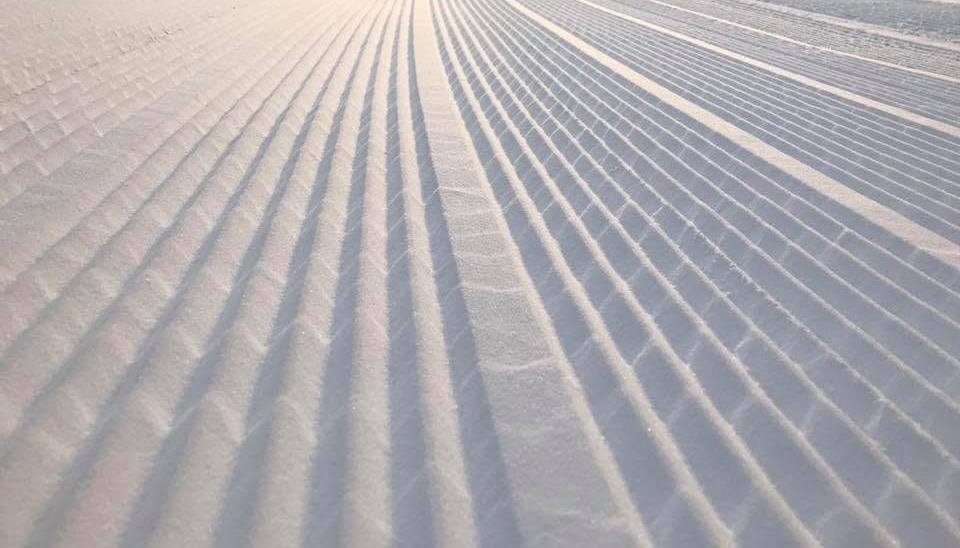 Fresh corduroy grooming lines on a snow trail near Ellicottville at first light