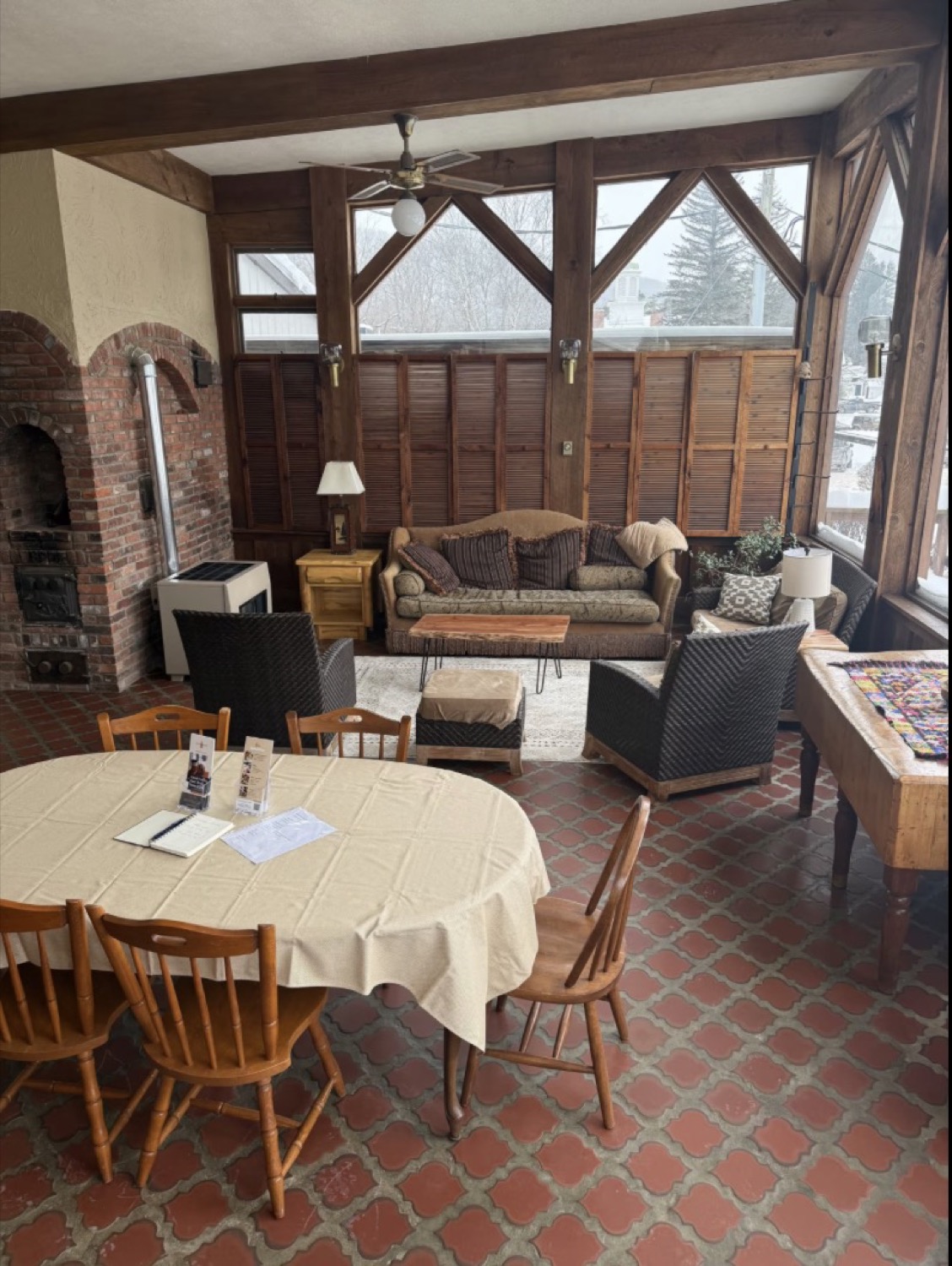 Timber-framed sunroom lounge at the featured village Airbnb overlooking snowy Ellicottville