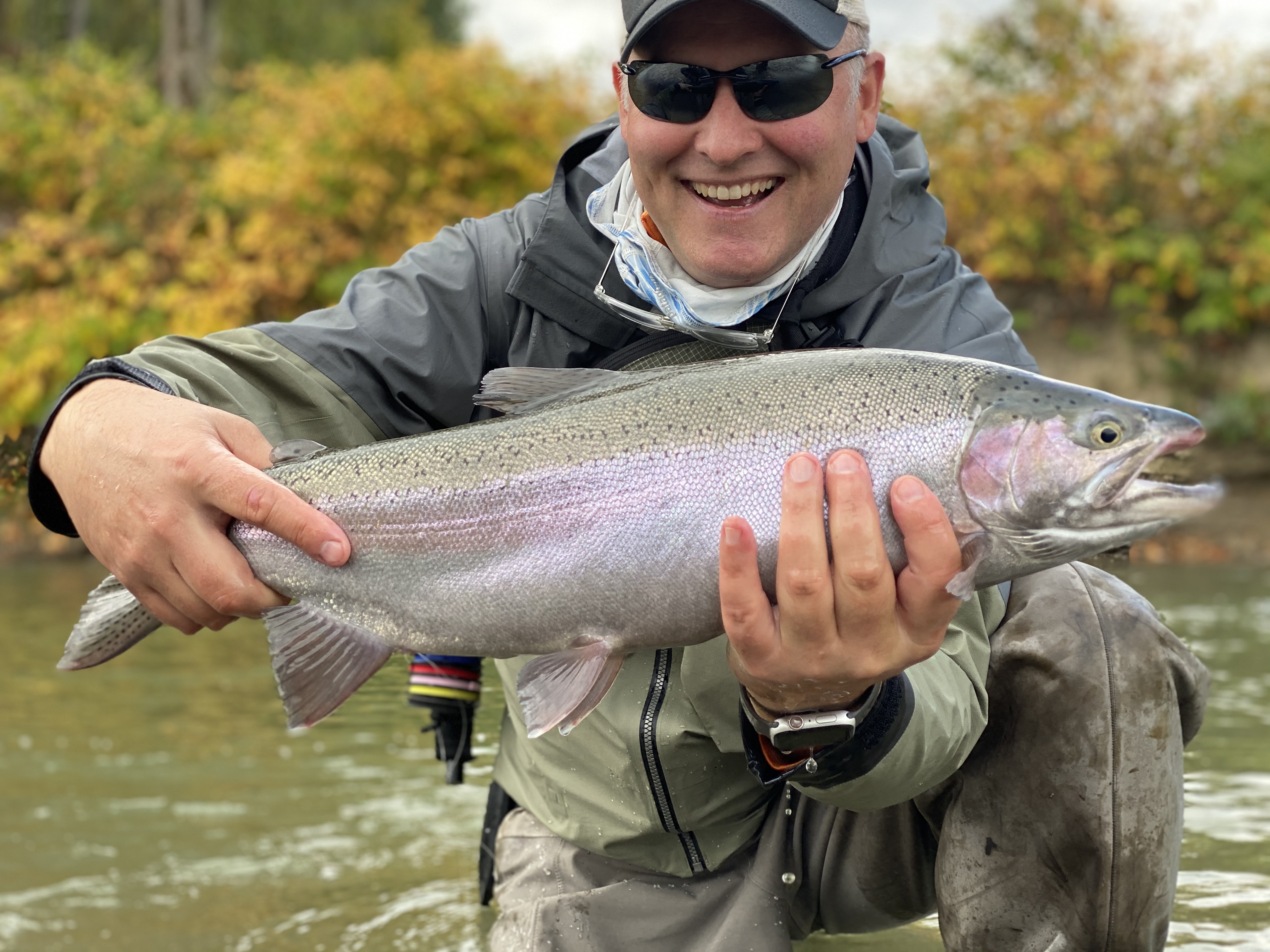 Smiling angler holding a chrome fall steelhead near Ellicottville