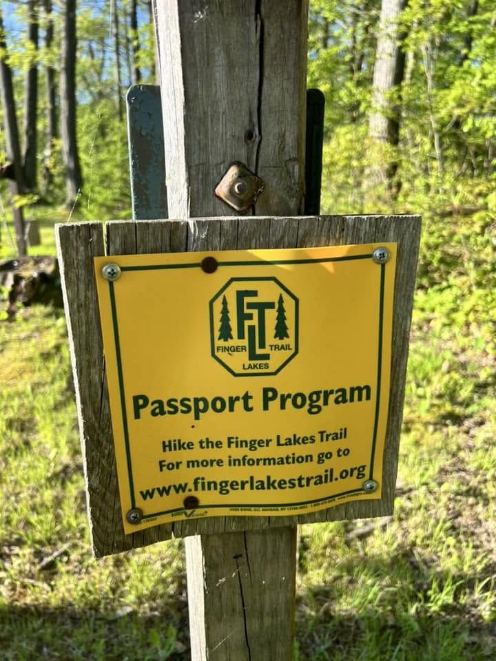 Finger Lakes Trail Passport Program sign on a wooden post near Ellicottville