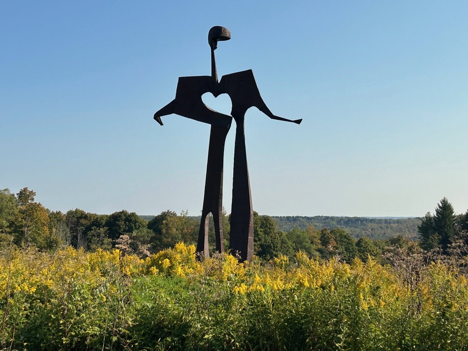 Heart-shaped couple sculpture rising from goldenrod at Griffis Sculpture Park near Ellicottville