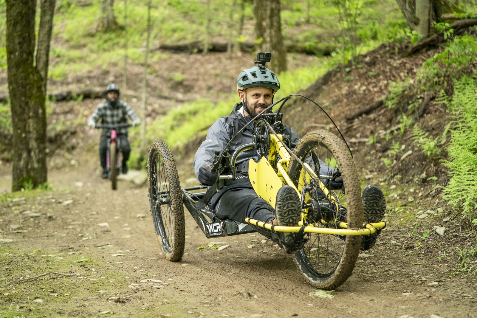 Adaptive rider descending a HoliMont trail on an off-road handcycle