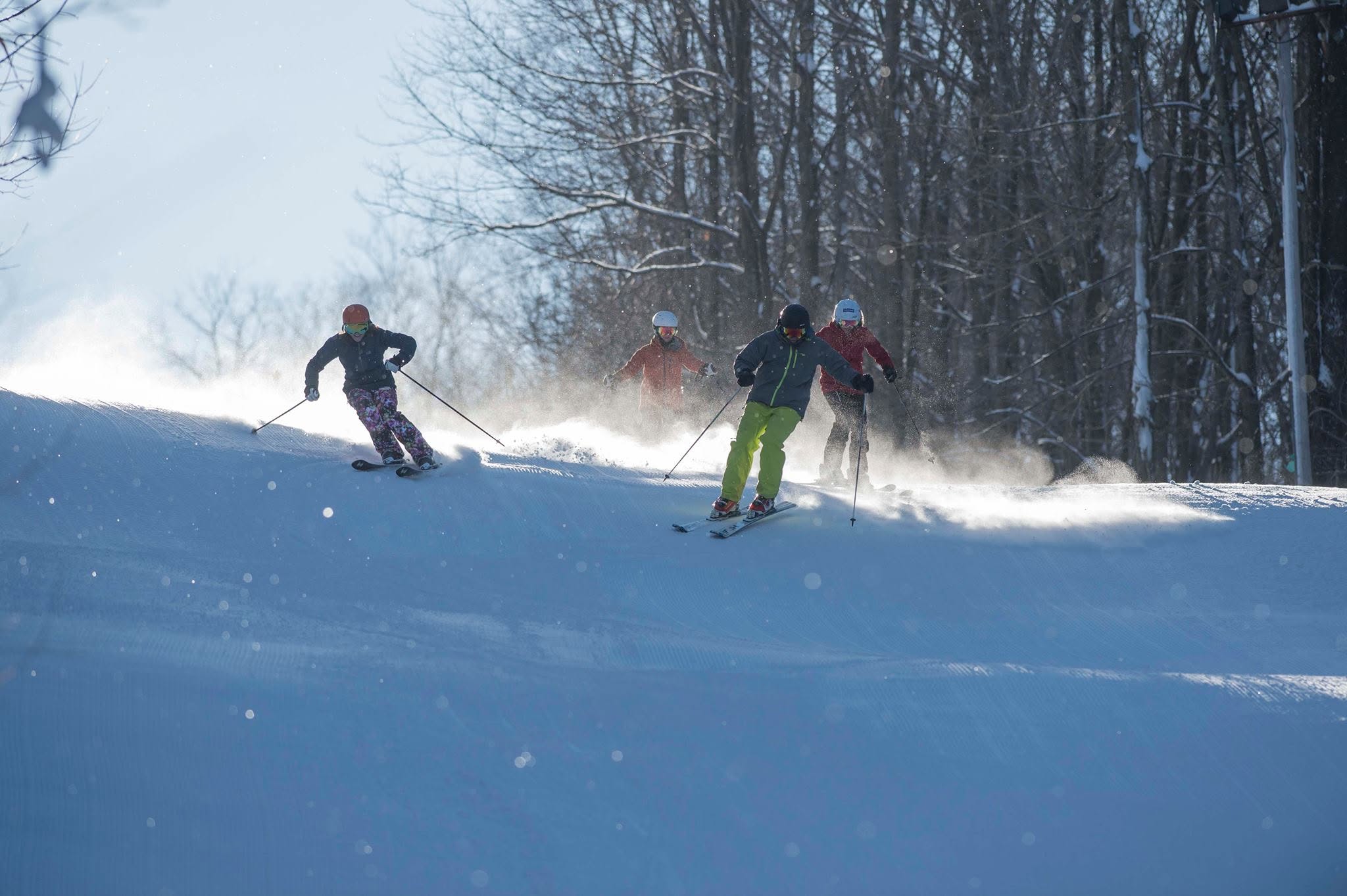 Skiers carving down a groomed run at Ellicottville in winter